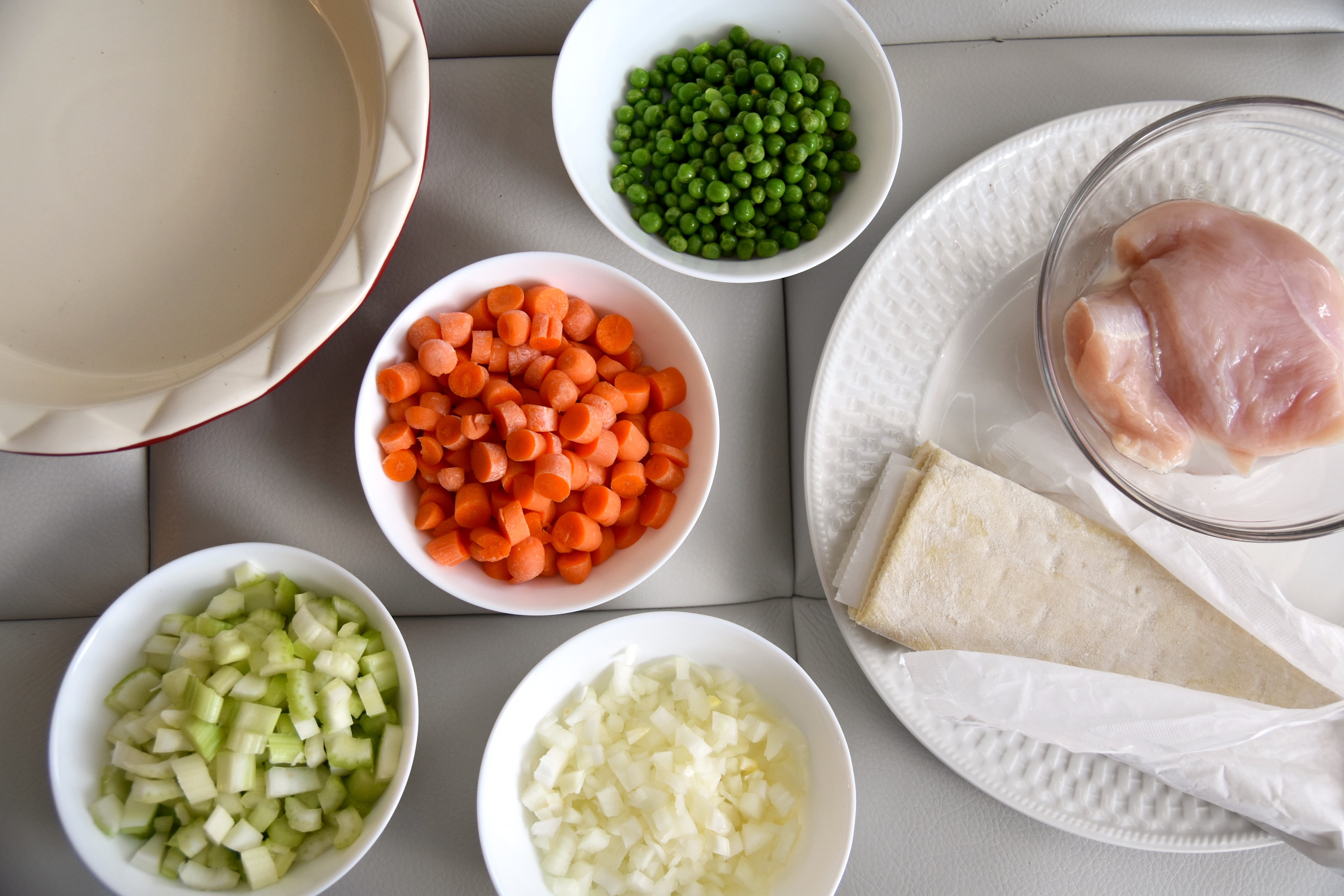 Chicken Pot Pie ingredients with onion, celery, carrot, peas, chicken, and puff pastry