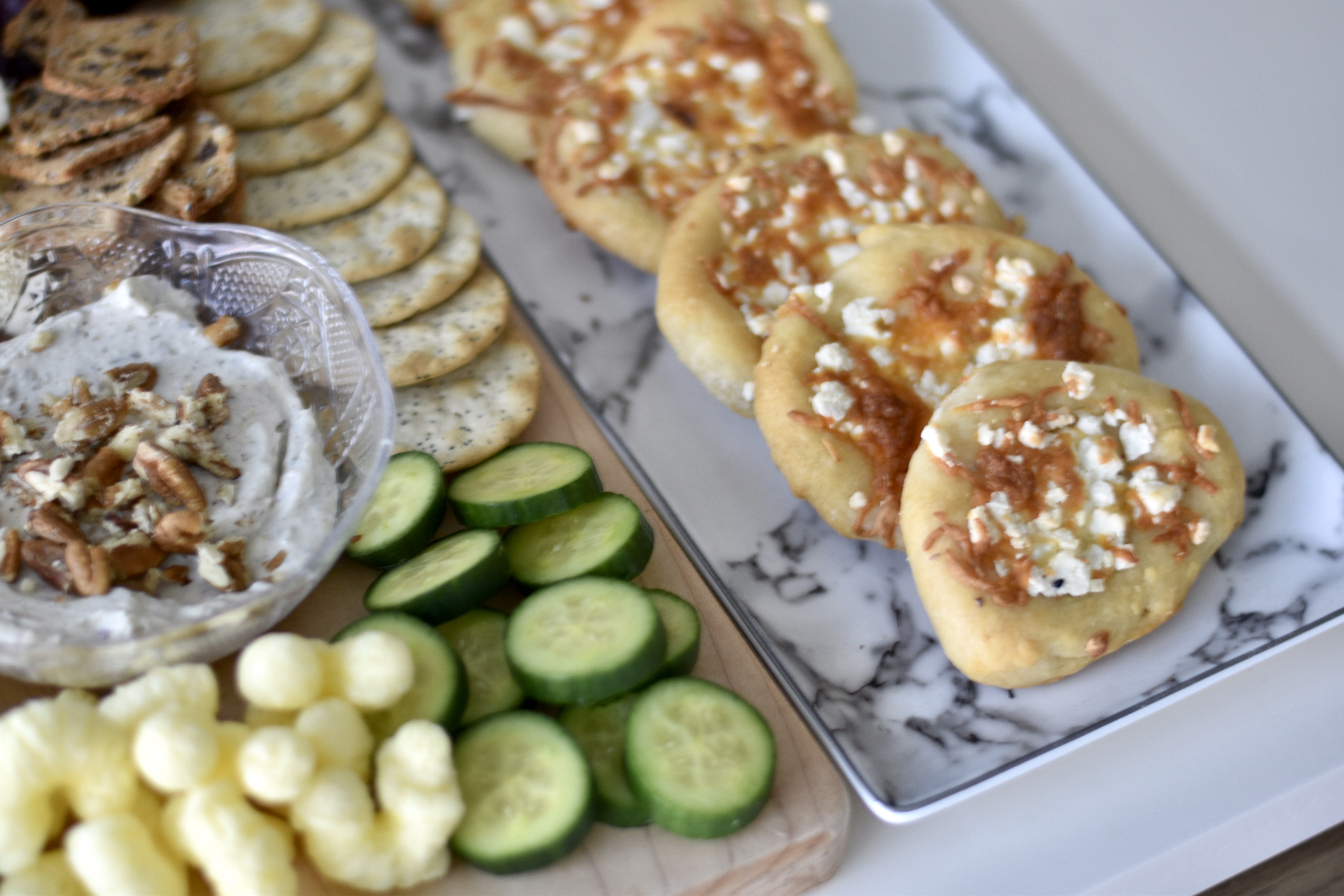 Cheese manakish, crackers, and cucumbers