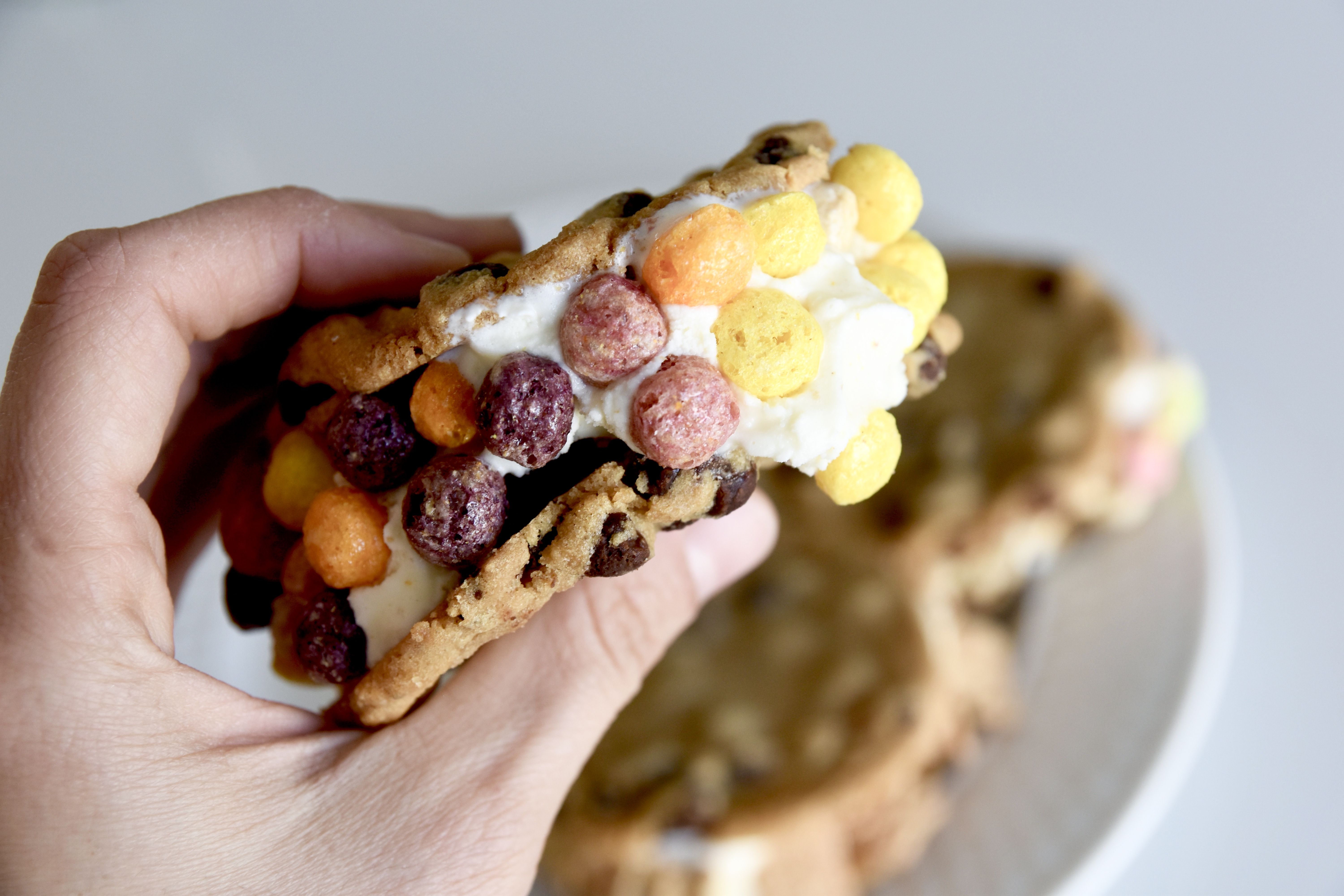 up close photo of ice cream sandwich rolled in trix cereal