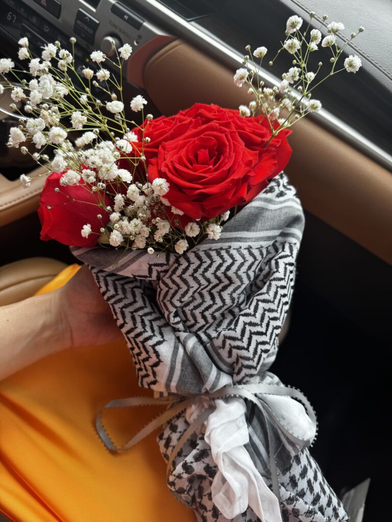 Bouquet of red roses and baby’s breath wrapped in a keffiyeh