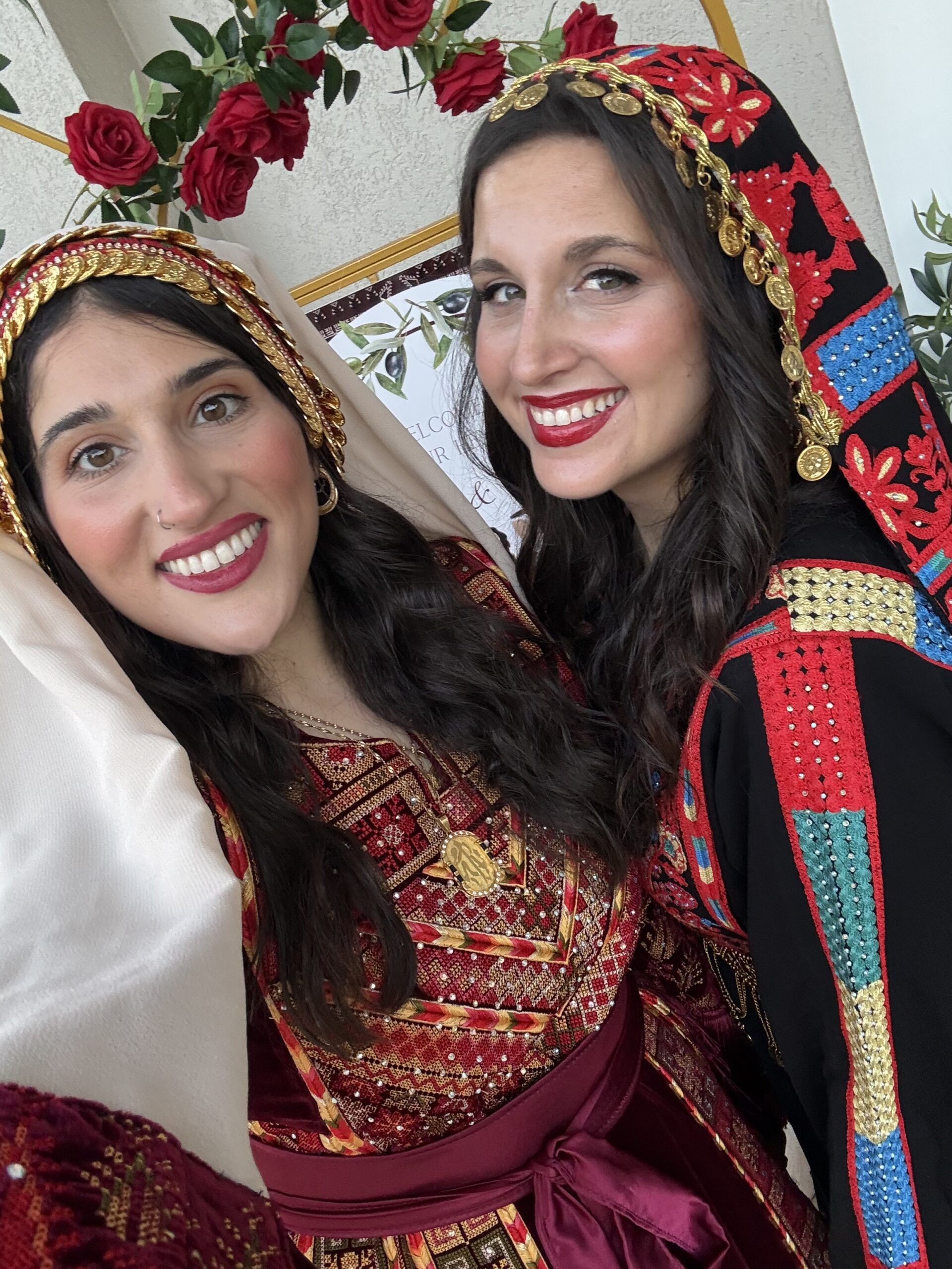 Dania and Aya smiling in embroidered Palestinian thobes